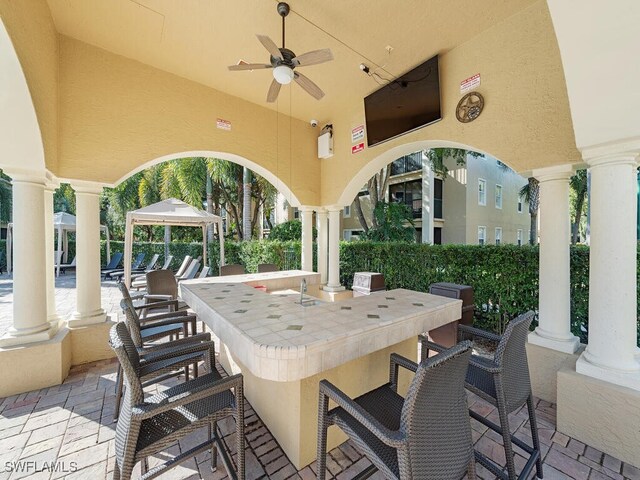 view of patio with a bar, ceiling fan, and a gazebo