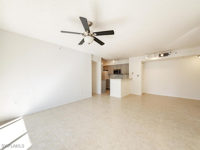 unfurnished living room with ceiling fan, light tile patterned flooring, and a textured ceiling