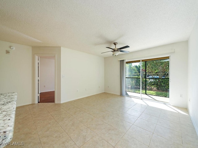 tiled empty room featuring a textured ceiling and ceiling fan