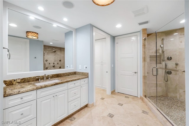 bathroom featuring vanity and a shower with shower door