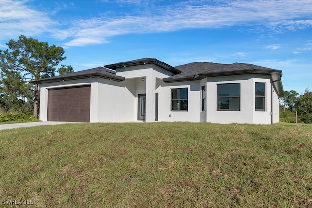 prairie-style home with a garage and a front lawn