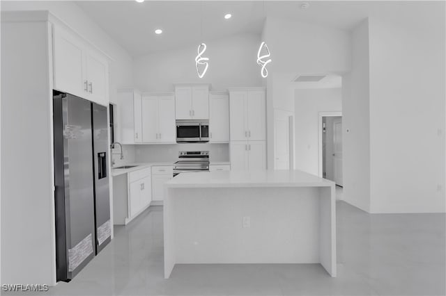 kitchen with white cabinets, a center island, stainless steel appliances, and vaulted ceiling