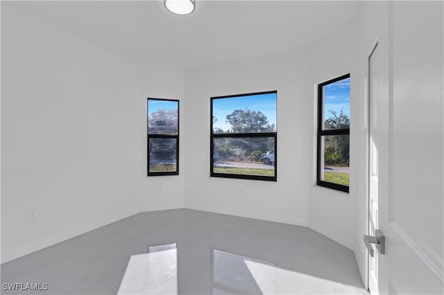 spare room featuring plenty of natural light and concrete flooring