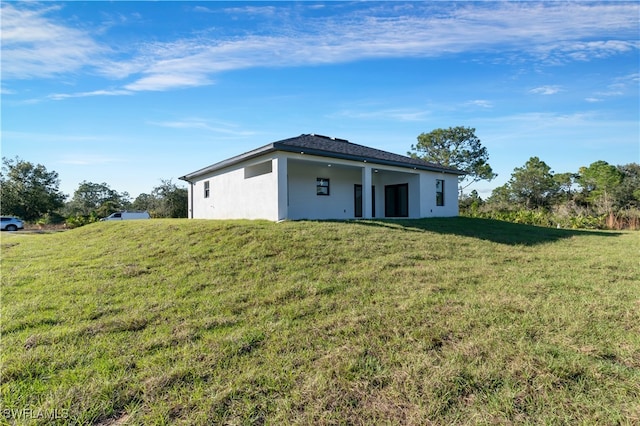 back of property with a lawn