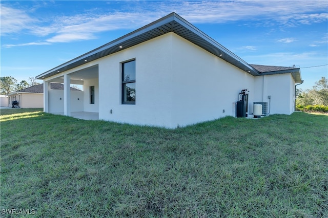 rear view of house featuring a lawn and a patio