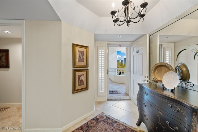 tiled foyer featuring an inviting chandelier