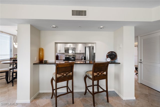 kitchen featuring stainless steel appliances, kitchen peninsula, and a breakfast bar