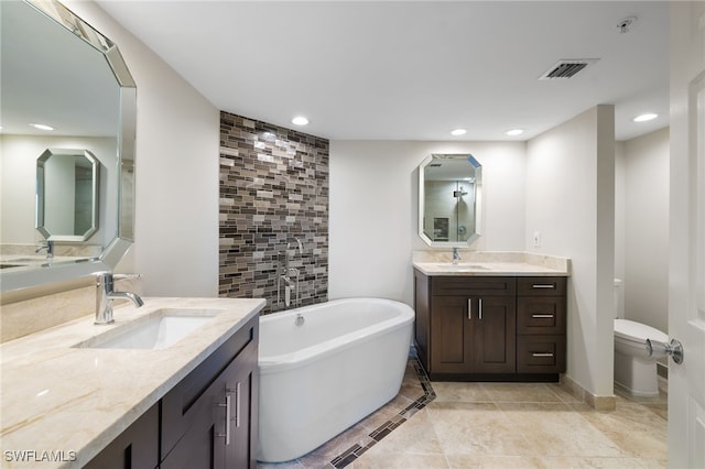 bathroom featuring vanity, a bathtub, and toilet