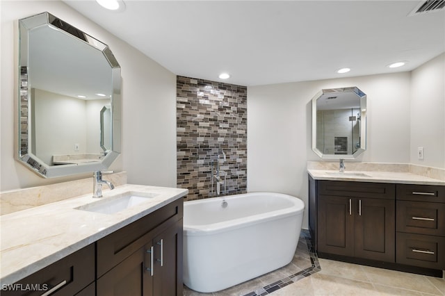 bathroom featuring a washtub, vanity, and tile patterned floors