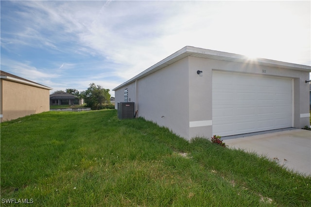 view of side of home with a yard, a garage, and cooling unit