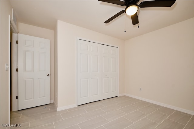 unfurnished bedroom featuring ceiling fan and a closet