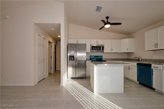 kitchen featuring appliances with stainless steel finishes, vaulted ceiling, ceiling fan, a center island, and white cabinetry