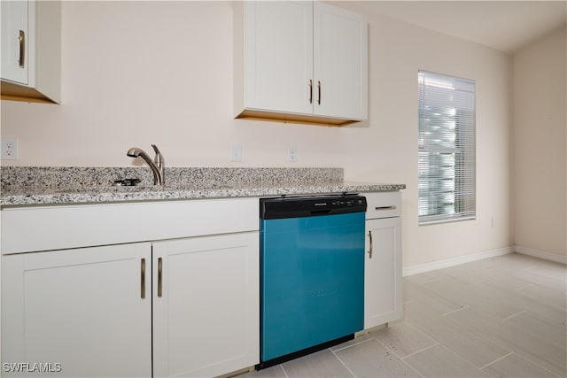 kitchen featuring light stone counters, sink, white cabinets, and stainless steel dishwasher