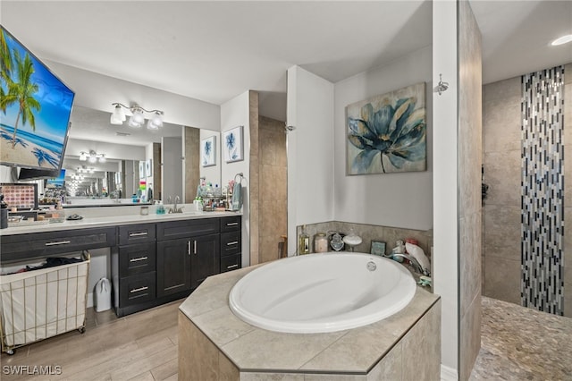 bathroom featuring hardwood / wood-style floors, vanity, and separate shower and tub