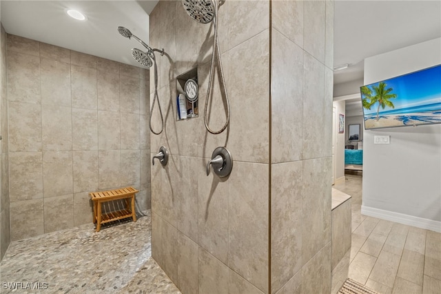 bathroom with wood-type flooring and tiled shower