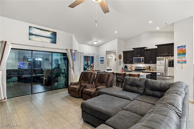 living room with ceiling fan, high vaulted ceiling, and light wood-type flooring