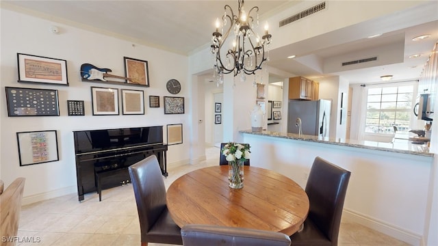 dining area with light tile patterned floors and a chandelier