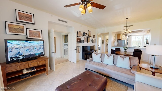 living room with ceiling fan with notable chandelier and light tile patterned floors