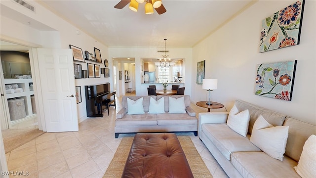 living room with ceiling fan with notable chandelier and light tile patterned floors