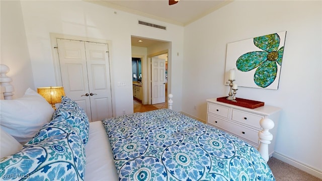 bedroom featuring light colored carpet, a closet, and ceiling fan