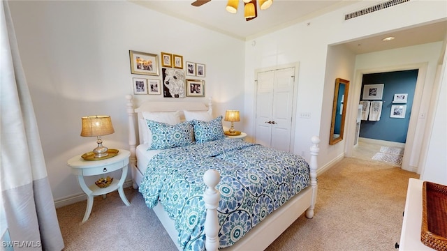 carpeted bedroom with ceiling fan and a closet