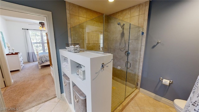 bathroom with tile patterned floors, ceiling fan, toilet, and an enclosed shower