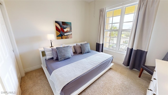 bedroom with light carpet and multiple windows