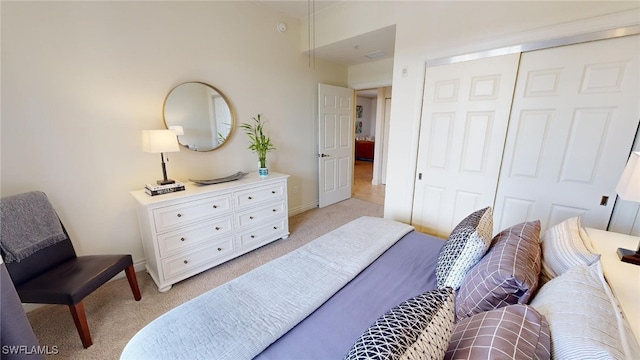 bedroom with light colored carpet and a closet