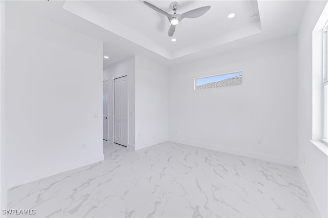 spare room featuring ceiling fan and a tray ceiling