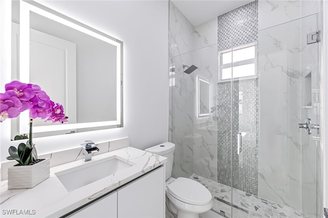 bathroom with a shower with door, vanity, and toilet