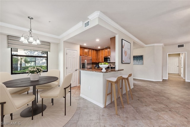 kitchen featuring hanging light fixtures, stainless steel appliances, kitchen peninsula, crown molding, and a chandelier