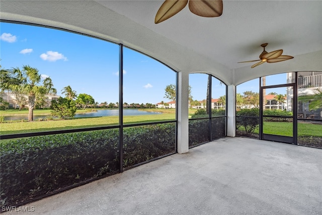 unfurnished sunroom featuring a water view and ceiling fan