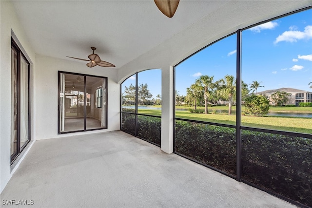 unfurnished sunroom with ceiling fan