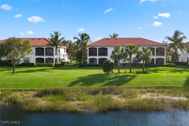 rear view of property featuring a yard and a water view