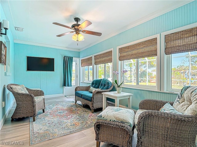 living room with ceiling fan, light wood-type flooring, and crown molding