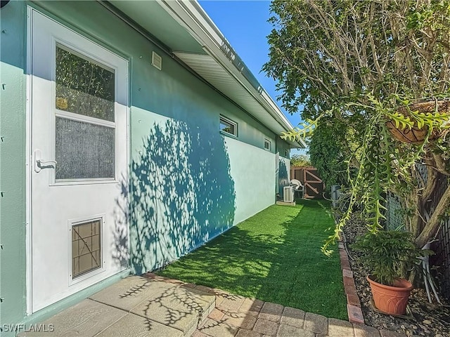 view of side of property with a yard and central air condition unit