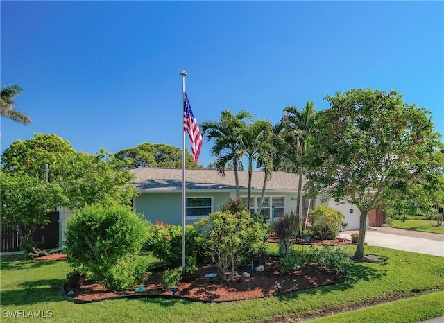 view of front of home with a garage and a front lawn