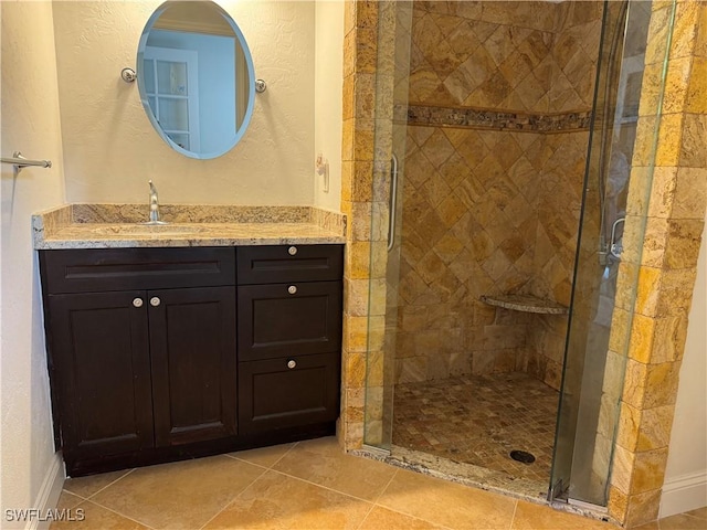 bathroom with tile patterned flooring, vanity, and an enclosed shower