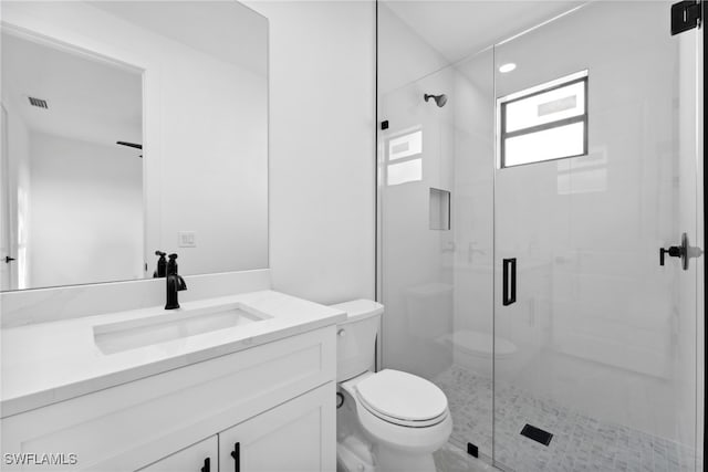 bathroom with walk in shower, vanity, and toilet