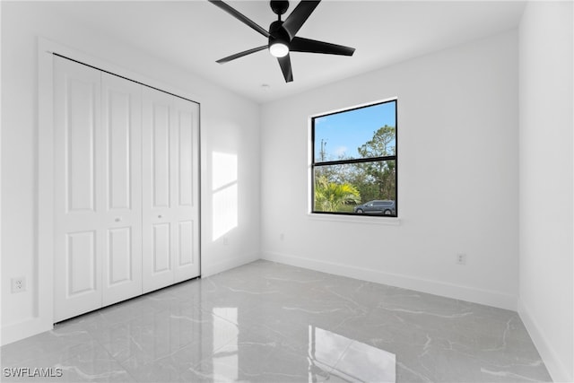 unfurnished bedroom featuring ceiling fan and a closet