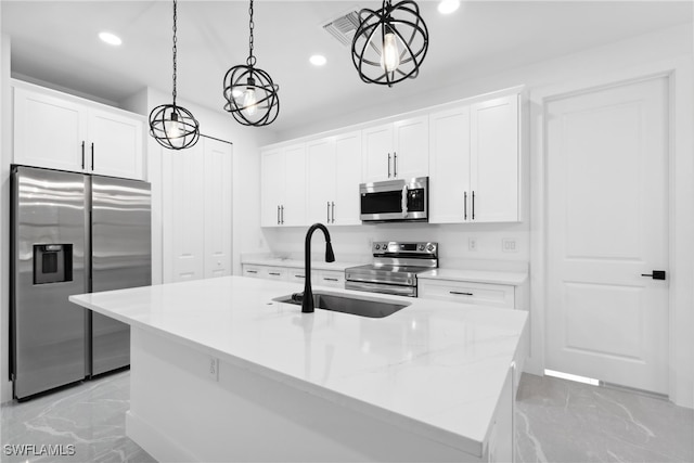 kitchen featuring appliances with stainless steel finishes, a center island with sink, and pendant lighting