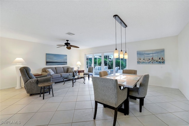 dining area with light tile patterned floors, a textured ceiling, and ceiling fan