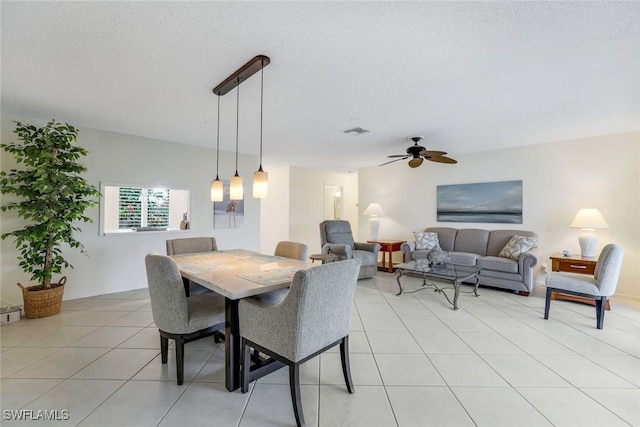 tiled dining room featuring a textured ceiling and ceiling fan