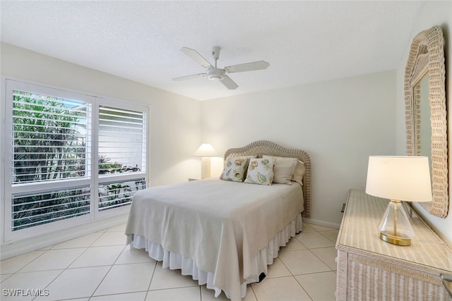 bedroom with a textured ceiling, ceiling fan, and light tile patterned flooring