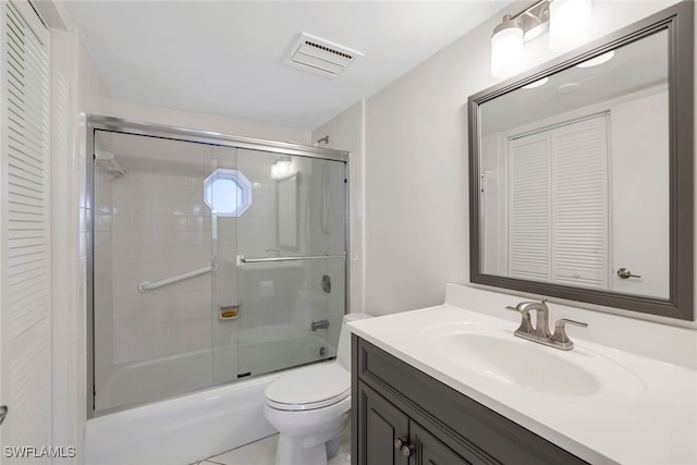 full bathroom featuring tile patterned floors, vanity, enclosed tub / shower combo, and toilet