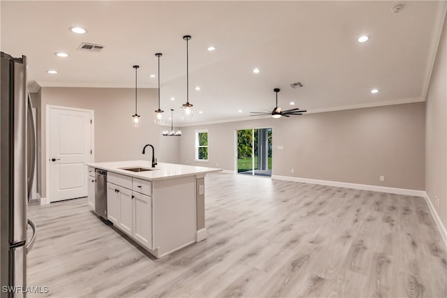 kitchen with open floor plan, light countertops, appliances with stainless steel finishes, an island with sink, and pendant lighting