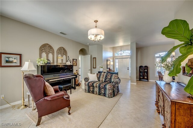 living room with light tile patterned floors and a chandelier