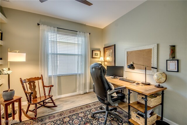 home office with light hardwood / wood-style floors and vaulted ceiling