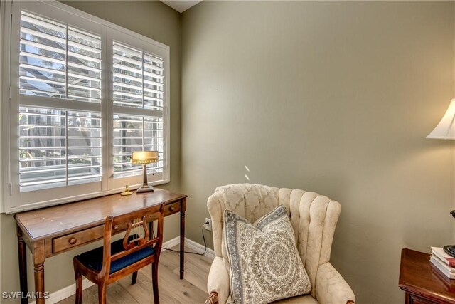 sitting room with baseboards and light wood-style floors