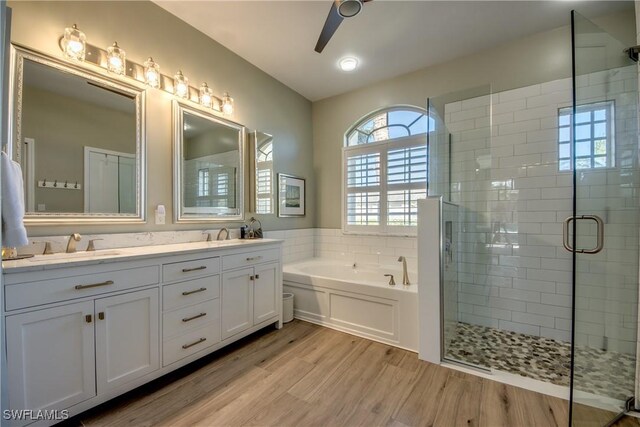 bathroom featuring vanity, ceiling fan, wood-type flooring, and shower with separate bathtub